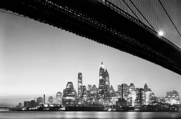 Lower Manhattan skyline at night, taken from underneath the Brooklyn Bridge in 1938.